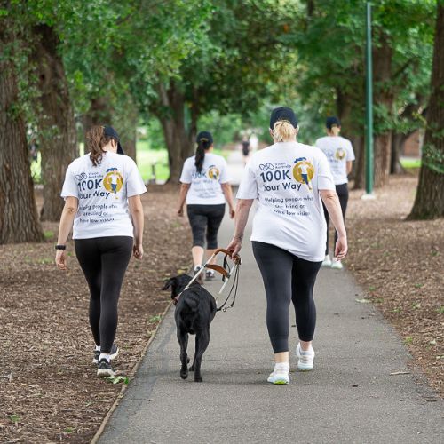 Women wearing 100KYW tshirts walking through a park