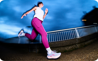 Woman runnning wearing white pair of Brooks runners with pink details