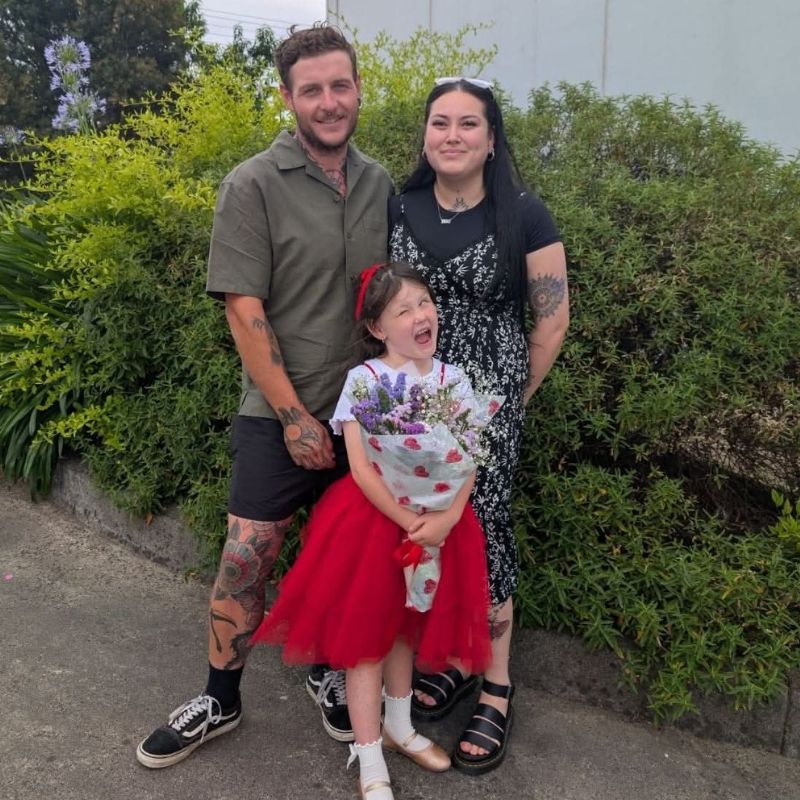 Lucy stands with her hands on her hips, smiling