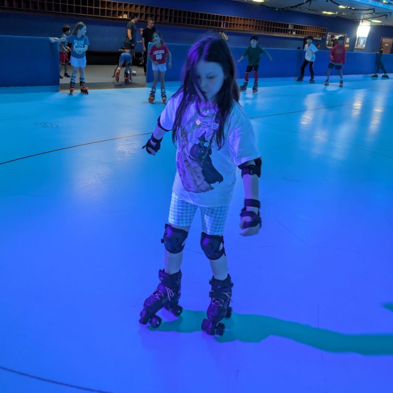 Luna is wearing roller skates on a skate rink