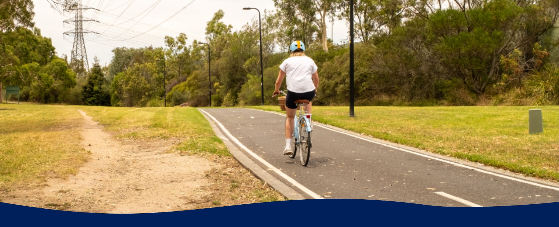 Woman rides a bike on a path through a park