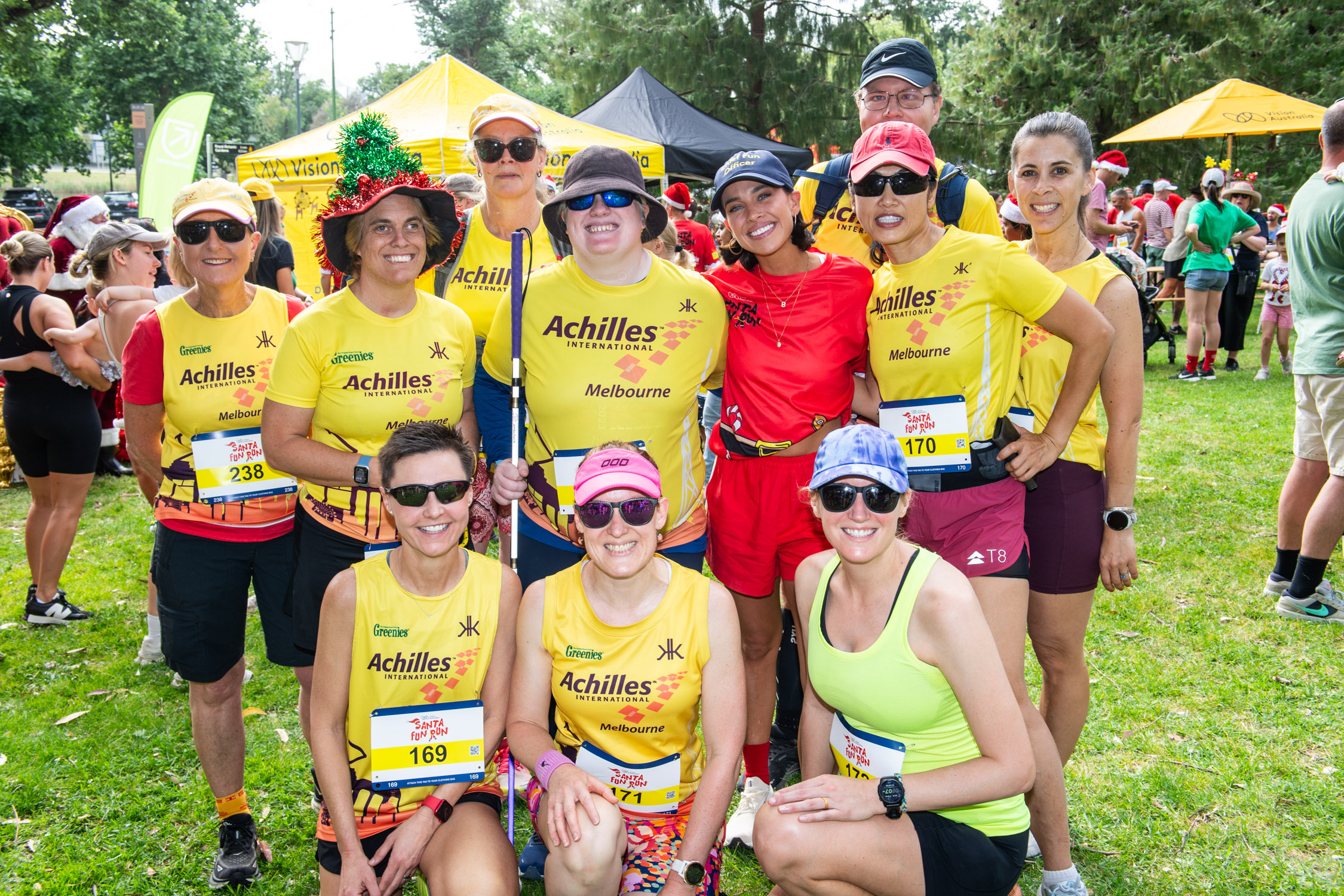 A group of people in yellow shirts and running gear smiling in a group photo