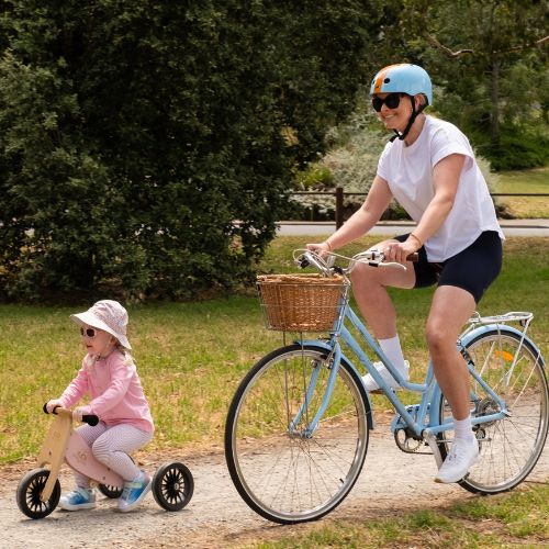 Little girl and woman ride bikes in a park