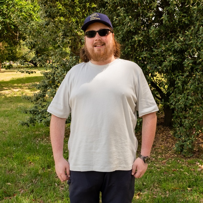 Sam standing in a park with sunglasses