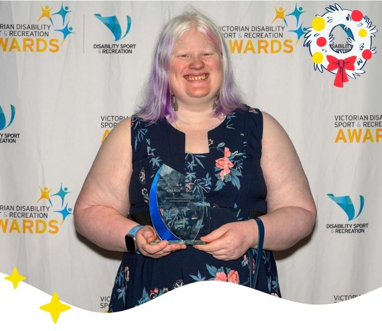 Woman smiling holding a glass trophy