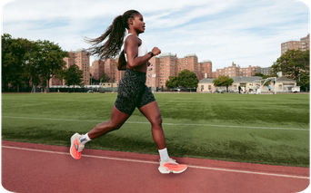 Woman running on a track wearing Brooks sneakers